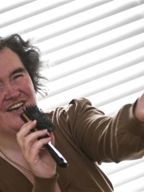 Susan Boyle poses singing with a hairbrush at her home in Blackburn, Scotland, in this April file...