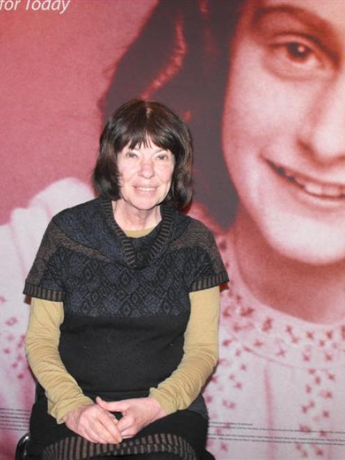 Susanne Ludanff, sits in front of an Anne Frank billboard at the Lakes District Museum on Sunday....