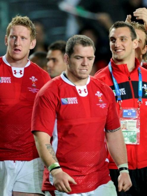 Suspended Wales captain Sam Warburton (R) walks on the field with his teammates after their Rugby...