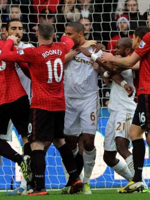 Swansea City and Manchester United players scuffle after a foul on Robin Van Persie (L) during...