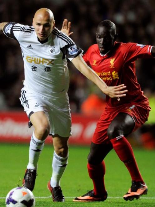 Swansea City's Jonjo Shelvey (L) passes Liverpool's Mamadou Sakho before shooting to score a goal...