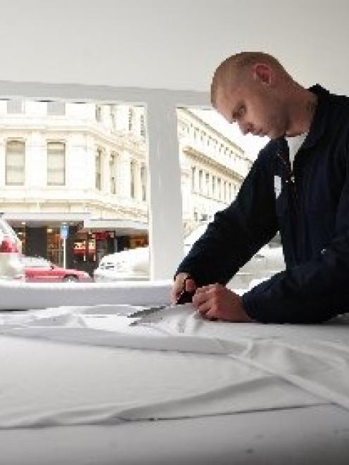 Dunedin man Jay Hutchinson cuts out a T-shirt in his makeshift ‘‘sweat shop’’ yesterday. Photo by...