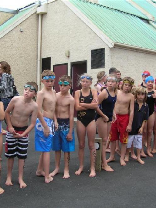 Swimmers wait for teammates outside the Cromwell Swim Centre before taking to the pool in the...