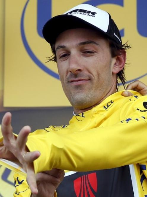 Switzerland's Fabian Cancellara wears the race leader's yellow jersey on the podium after the...