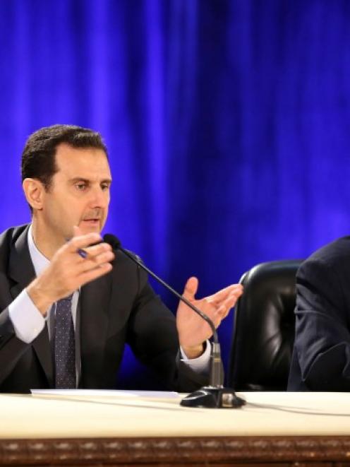 Syria's President Bashar al-Assad (L) meets professors and students of political science at a...