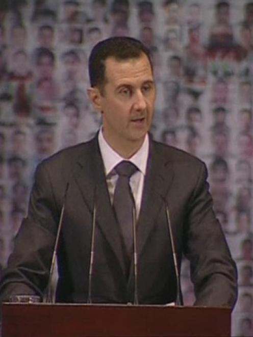 Syrian President Bashar al-Assad speaks at the Opera House in Damascus in this still image taken...
