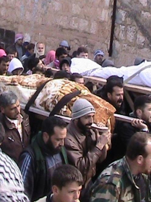 Syrians carry the bodies of members of the Free Syrian Army who were killed by the government's...