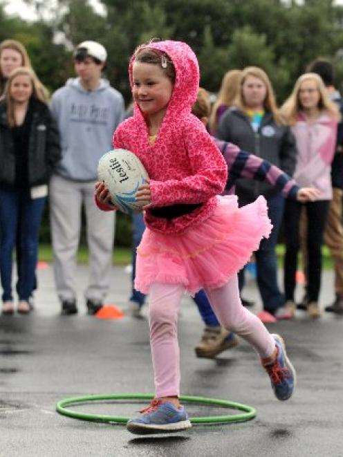 Taieri Beach School pupil Hannah Jaquiery (6) shows students from High Point University, North...