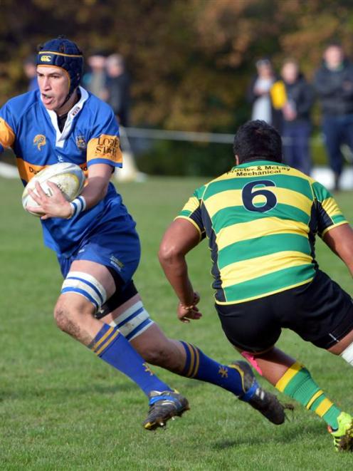 Taieri lock Mike McKee jinks past Green Island flanker Lausei Pritchard at Miller Park on...