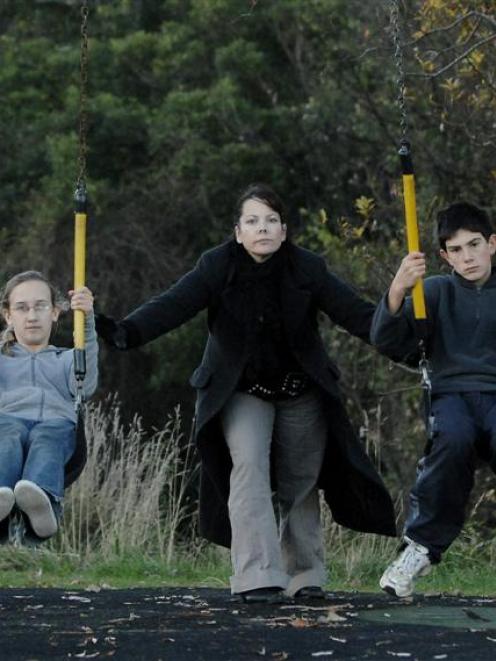 Dunedin author Tania Roxborogh pushes teenagers Katarina Konings and David Trebilco on swings in...