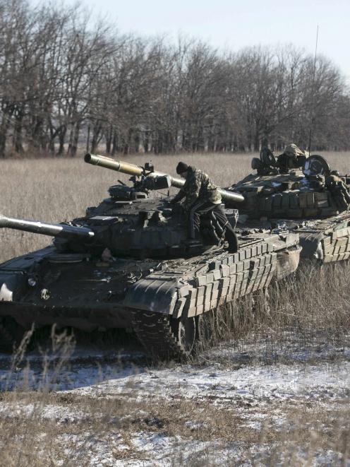 Tank crews of the separatist self-proclaimed Donetsk People's Republic Army stand on top of their...