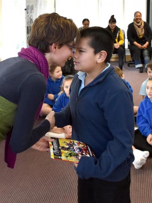 Te Kura Kaupapa Maori o Otepoti school pupil Tumai Joseph Campbell (8) receives his book from...