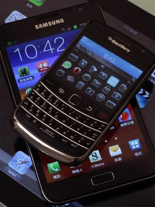 The Blackberry Bold smartphone, Samsung Galaxy Note phablet and Apple iPad 2 tablet are displayed...