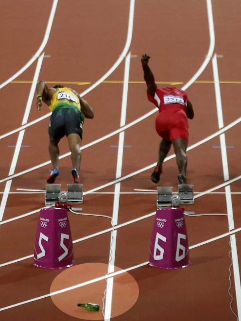 The bottle can be seen on the track as the men's 100m final starts. Photo Reuters