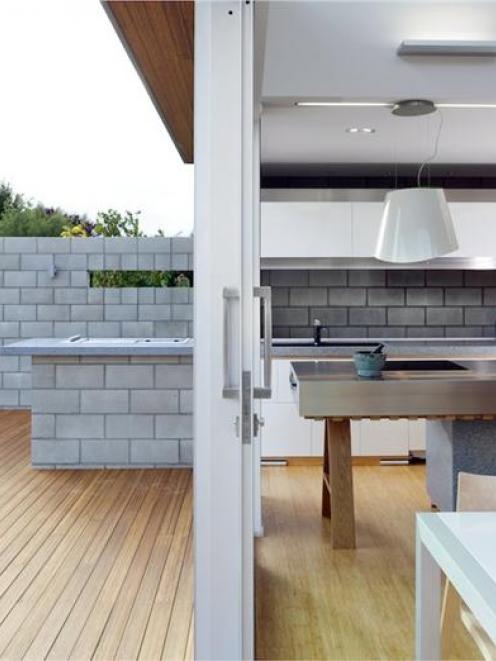 The concrete backdrop and cooking facilities extend on to the deck. When the glass door is slid...