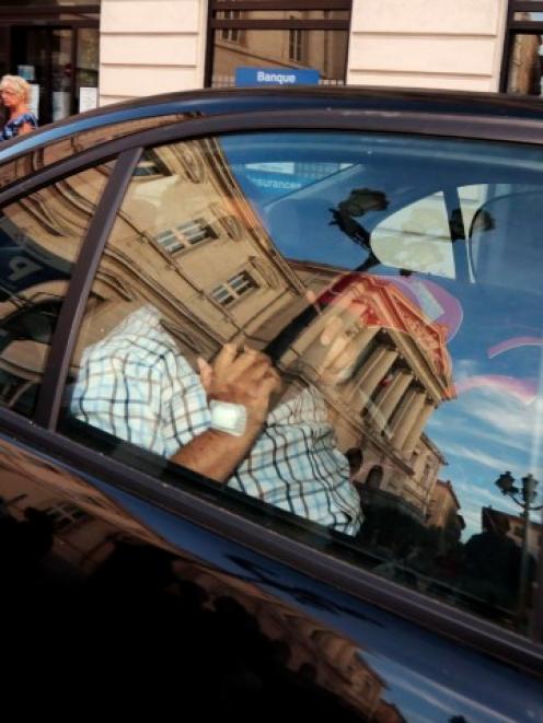 The courthouse in Nice is reflected in the car window as Stephan Turk leaves after being indicted...