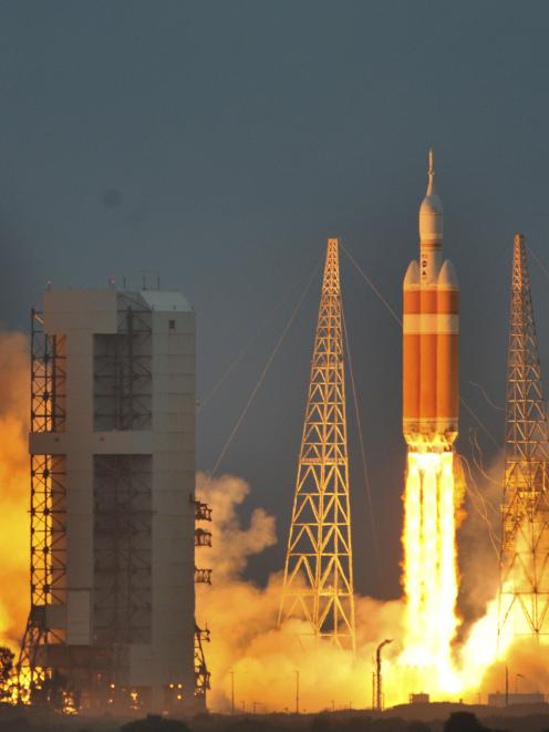 The Delta IV Heavy rocket with the Orion spacecraft lifts off from the Cape Canaveral Air Force...