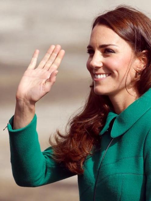 The Duchess of Cambridge waves after arriving with Prince William at Hamilton airport before...