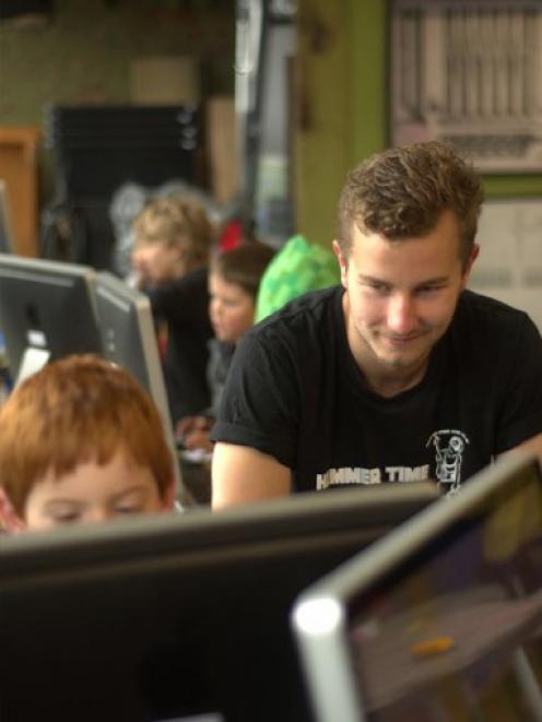 The Gasworks volunteer Alex McGregor watches a young Minecrafter at work. Photo supplied.