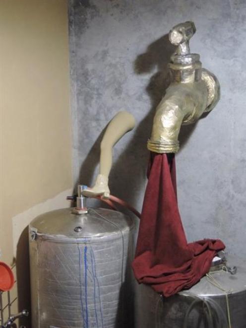 The giant papier-mache tap and burgundy cloth above tanks in Mount Edward's winery, made by...