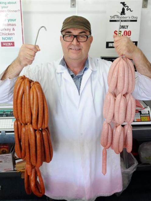 The Good Food Shop owner Ross Hutchison holds up two strings of his pork bratwurst sausages....