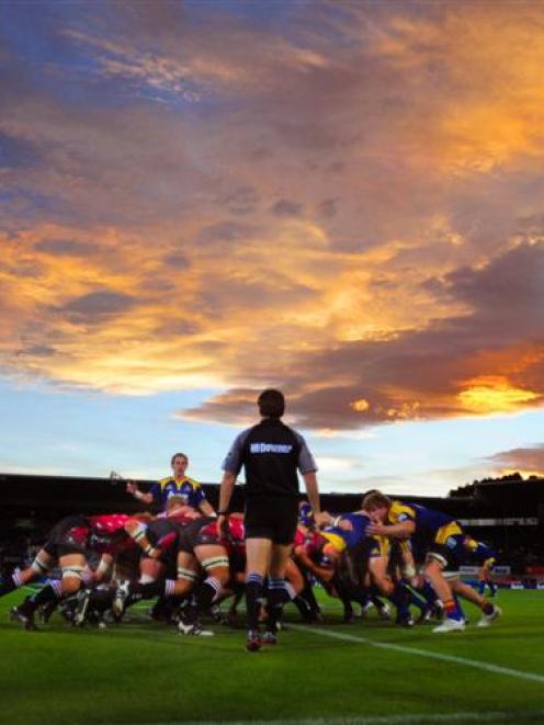 The Highlanders and the Lions pack down a scrum under a fiery sky in their Super 14 clash at...