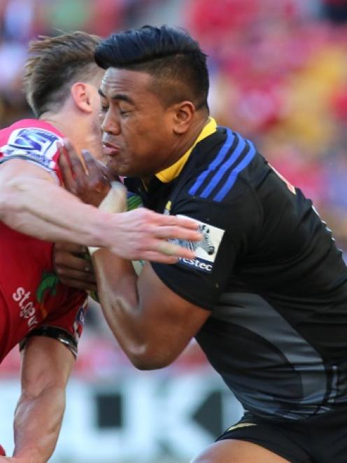 The Hurricanes' Julian Savea busts the ball up against the Reds. Photo by Getty Images