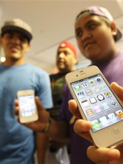 The Leon Guerrero family from Dallas show off their new Apple iPhone 4Ss which they bought in San...