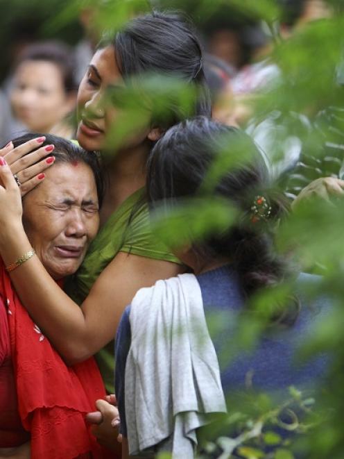 The mother (L) of flight attendant Ashmita Shrestha breaks down as she waits for the body of her...
