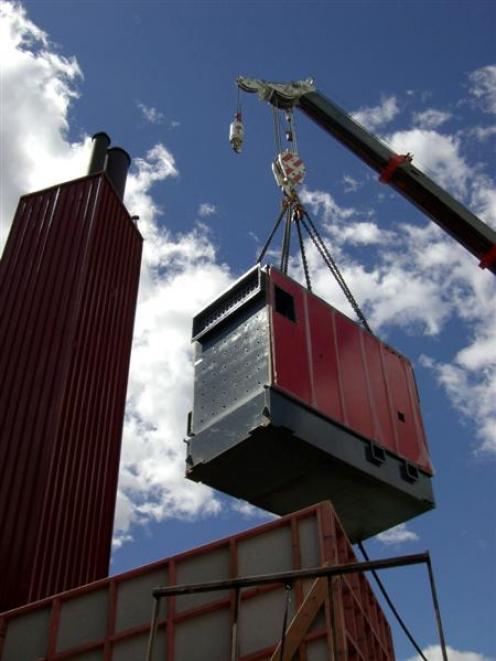 The new woodchip-fired boiler is carefully lifted into place at Dunstan High School next to the...