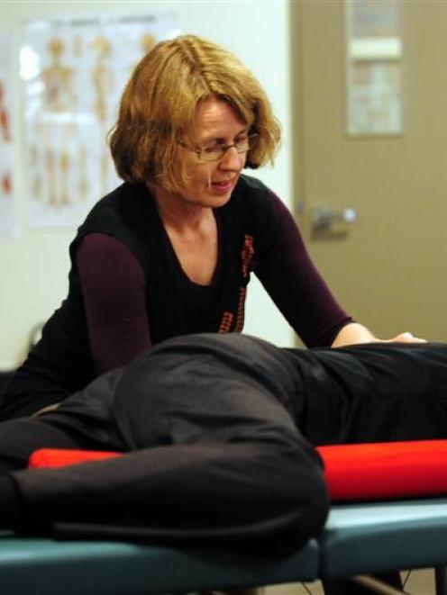 The practitioner performs the movements in a "functional integration" Feldenkrais session.
