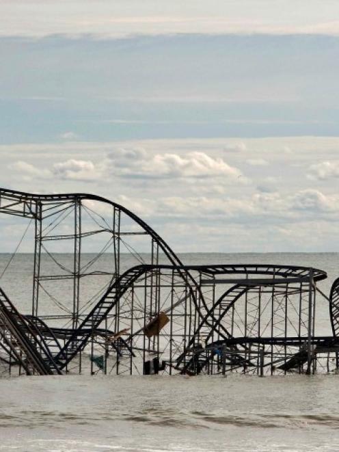 The remains of a roller coaster sit in the surf three days after Hurricane Sandy came ashore in...