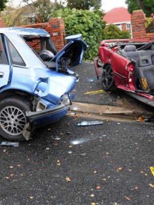 The remains of the pursued car (right) which struck two parked cars after becoming airborne over...