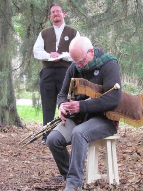 The Rev Tim Hurd (rear), of St Luke's Church,  stands in contemplation as Tony Gallagher  plays a...