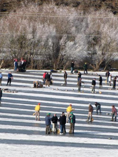 The sun came out briefly for curlers at yesterday's bonspiel on the Idaburn dam. Photos by Colin...