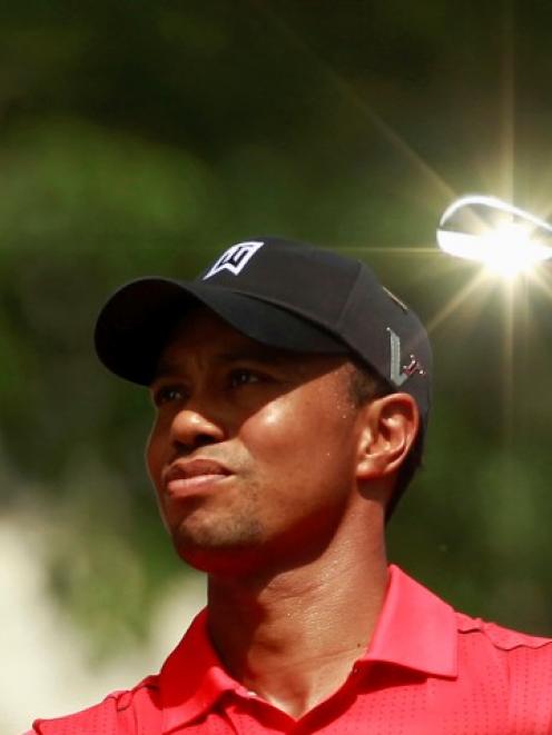 The sun reflects off the club as Tiger Woods hits off on the seventh tee during the final round...