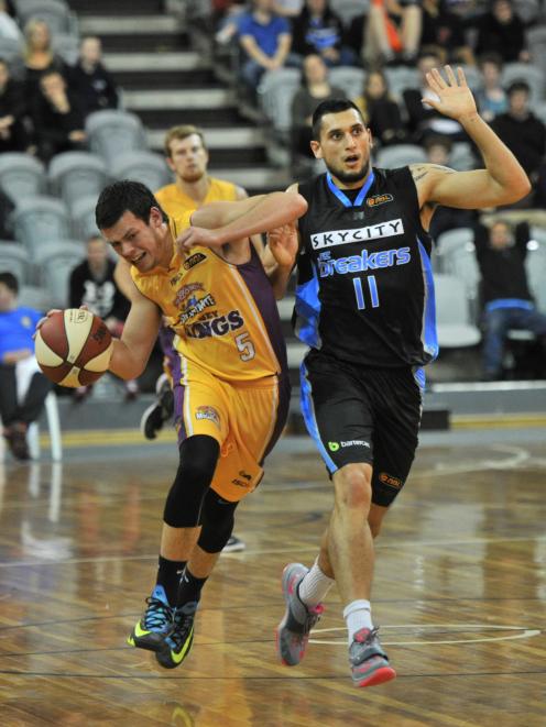 The Sydney Kings' Jason Cadee (left) is fouled by the New Zealand Breakers' Duane Bailey during...