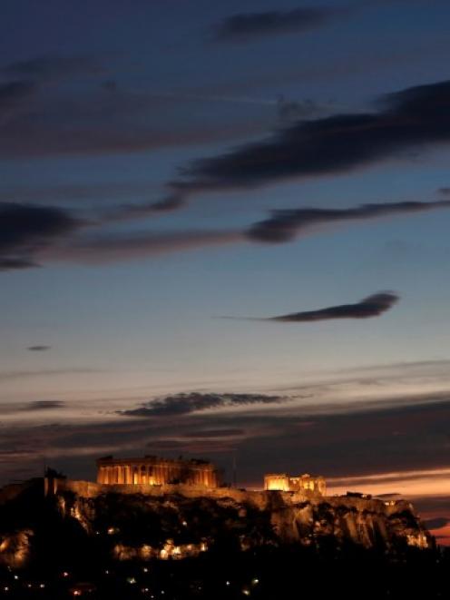 The temple of the Parthenon is illuminated at the Acropolis hill in Athens. REUTERS/John Kolesidis