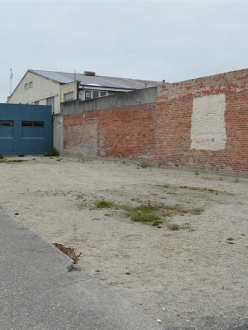 The vacant lot at the corner of Elizabeth  and Clyde Sts, with the Hairworkz building in the...
