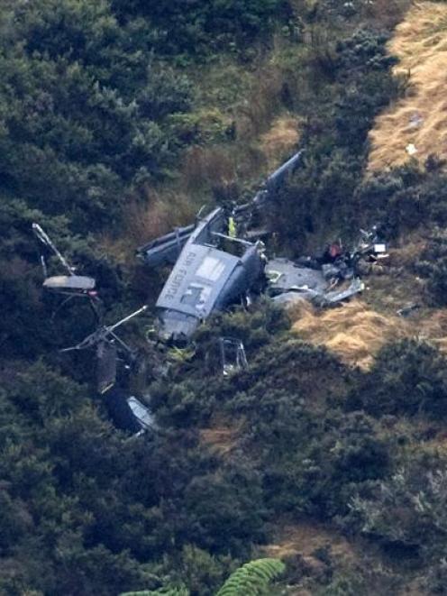 The wreckage of the Royal New Zealand Air Force Iroquois helicopter on the side of a hill in...