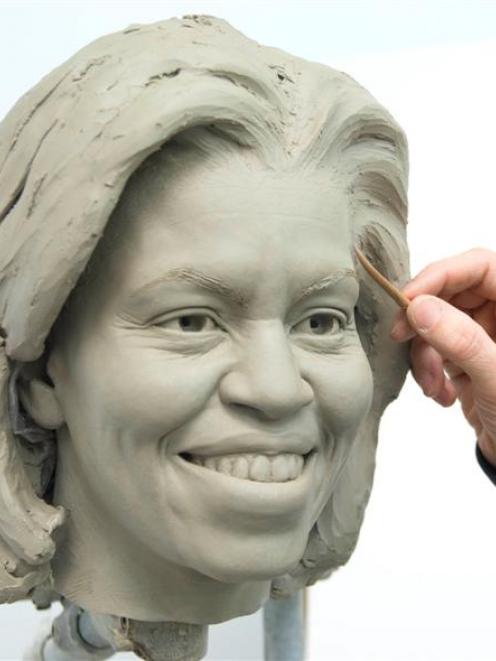 This image provided by Madame Tussauds shows senior sculptor Colin Jackson working on a clay head...