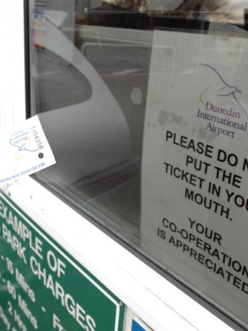 A sign in the window of a Dunedin International Airport parking booth requests people not to put...