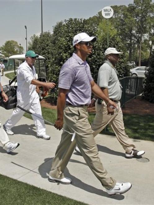 Tiger Woods arrives with his caddie Steve Williams, second from left, at the Augusta National...