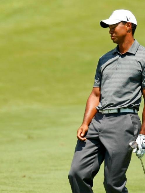 Tiger Woods reacts after his approach shot on the fourth hole during the first round of the...