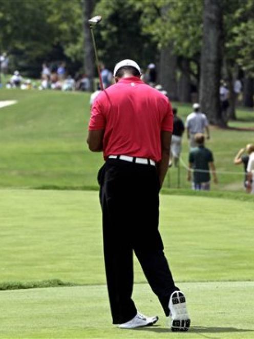Tiger Woods reacts after hitting a drive on the sixth hole during the first round of the PGA...