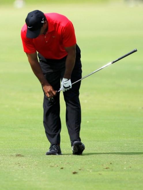 Tiger Woods reacts after hitting a shot on the sixth hole during fourth-round play in the WGC...