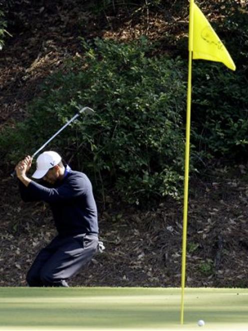 Tiger Woods reacts to missing a birdie chip on the 12th green. (AP Photo/Charlie Riedel)