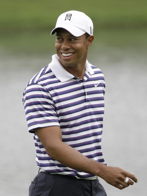 Tiger Woods walks on the eighth green after completing a putt during the Pro-Am competition of...