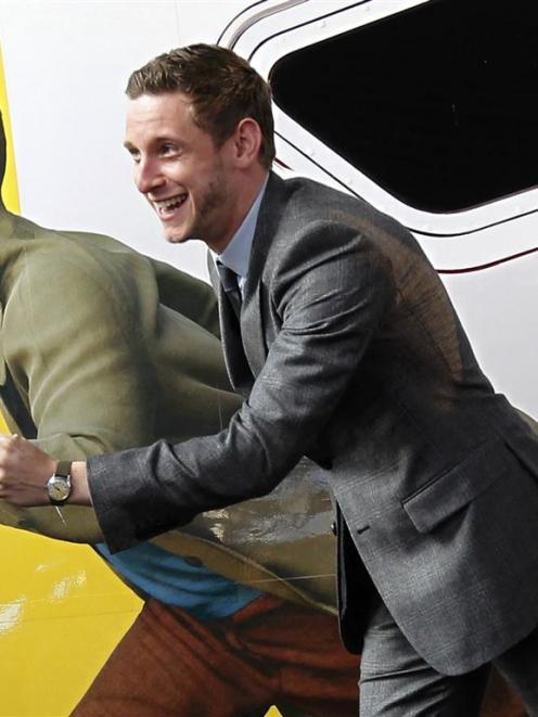 Tintin star Jamie Bell imitates a figure of Tintin, painted on a Thalys high-speed train, in...