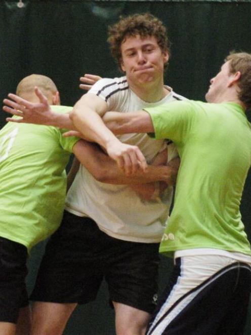Todd Anderson (Canterbury University) gets a pass away despite a challenge by two Otago Otago...